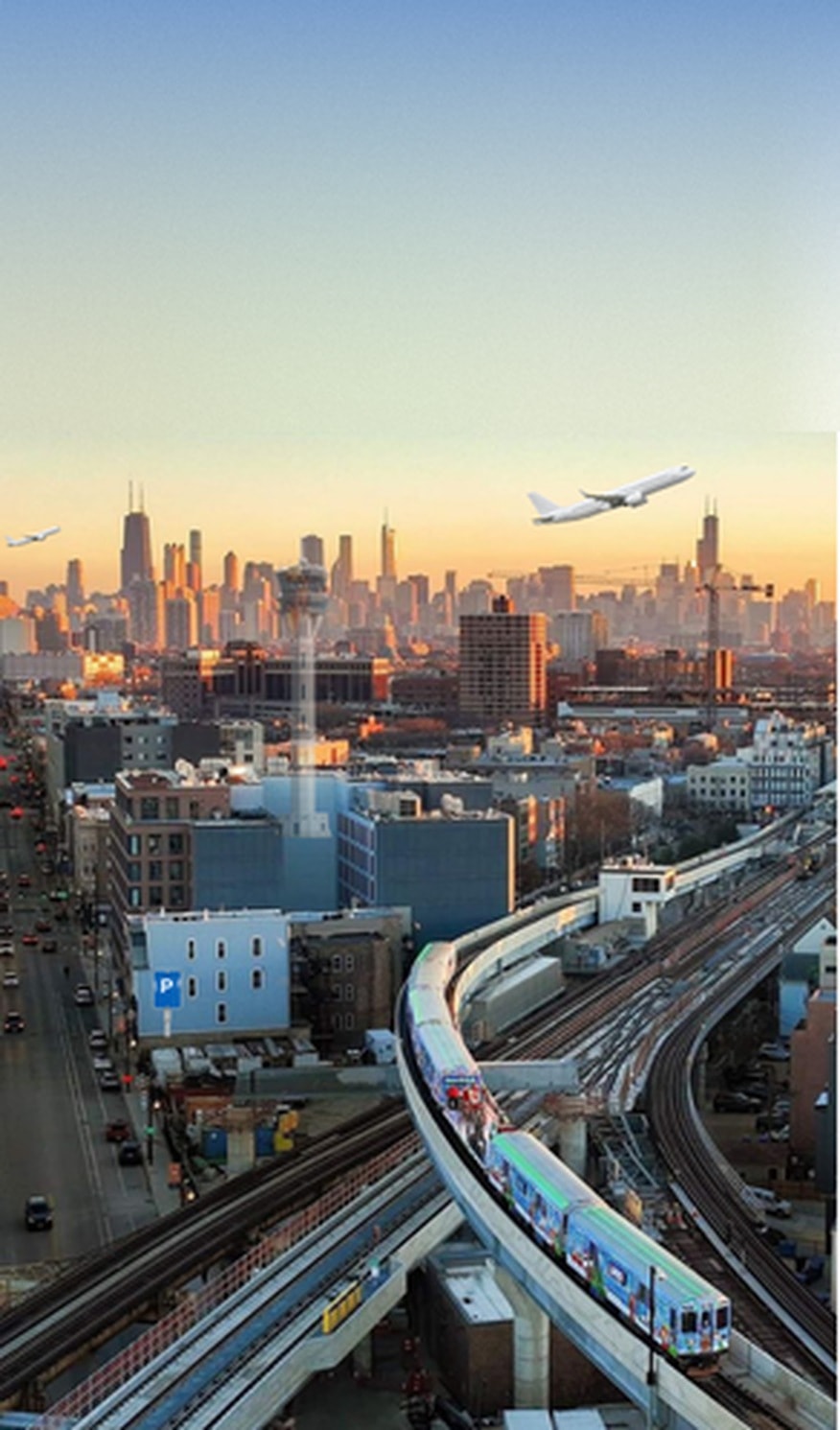 Commercial aircraft flying over the Chicago skyline with an elevated train at sunset